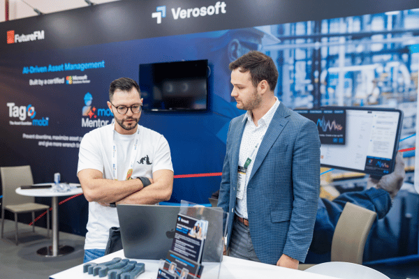 Exhibitor representatives discussing a facilities-management solution on a stand.